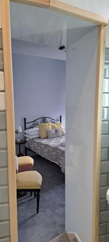 a bedroom with a bed and a chair in a room at Orchard House Hotel in Lynmouth