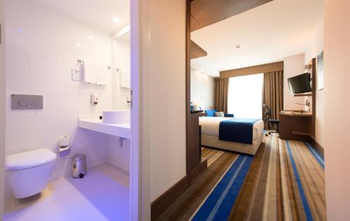 a hotel room with a bathroom with a bed and a sink at Liv City Hotels in Istanbul