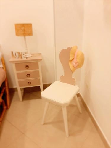 a white chair in a room with a dresser at LA MURGIA casa vacanze B&B in Grumo Appula