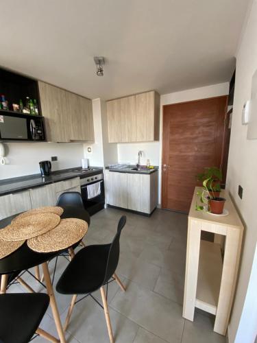 a kitchen with two tables and chairs in a kitchen at Departamento Central Valdivia in Valdivia