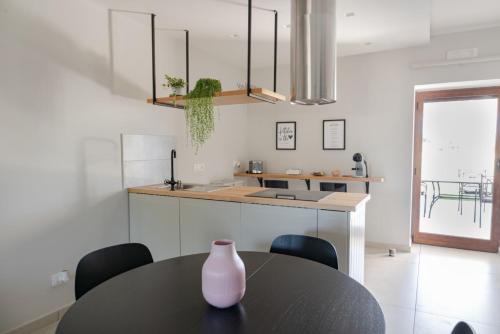 uma cozinha com uma mesa e um vaso em cima em Dimora Musco Bed & Breakfast em Castel Campagnano
