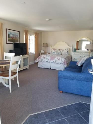 a bedroom with a bed and a blue couch at Riverside with balcony Sheepscot Harbour Vacation Club Studio #215 in Edgecomb
