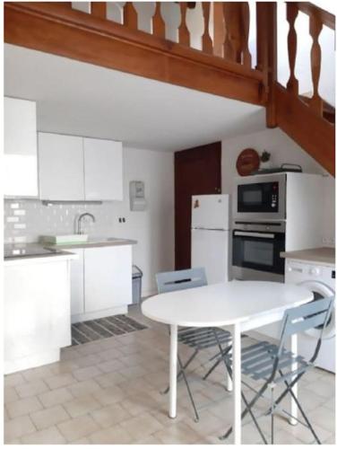 une cuisine avec une table blanche et un comptoir blanc dans l'établissement Maison T2 Terrasse Mezzanine, au Grau-dʼAgde
