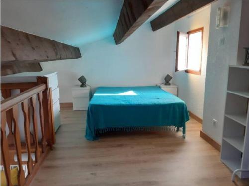 Un dormitorio con una cama con una manta azul. en Maison T2 Terrasse Mezzanine, en Le Grau d'Agde