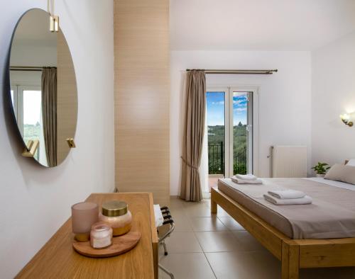 een slaapkamer met een bed en een tafel met een spiegel bij Villa Thallo in Galatás