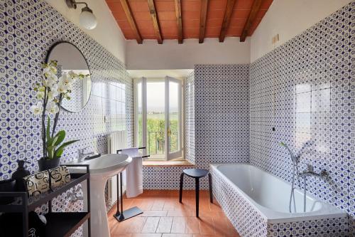 ein Badezimmer mit einer Badewanne, einem Waschbecken und einem Spiegel in der Unterkunft Agriturismo Borgo Scaffaia in San Piero a Sieve
