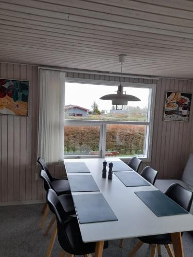 a dining room with a table and chairs and a large window at Øster Hurup in Hadsund