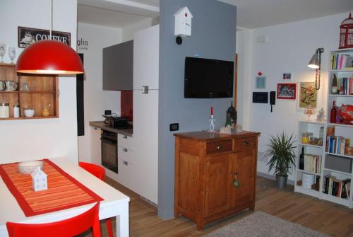 uma sala de estar com uma cozinha com uma mesa e uma televisão em Mini Midlake codice cipat 022229-AT-410061 em Mezzolago