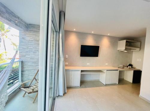 a room with a desk with a tv on the wall at Pousada Maracabana Spa in Porto De Galinhas