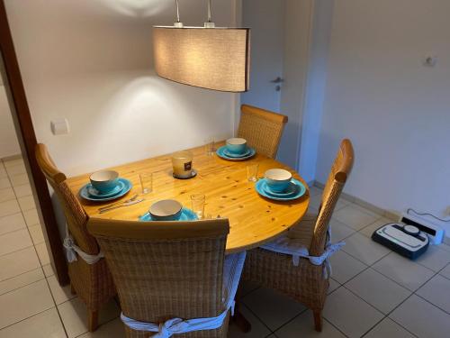 a dining room table with chairs and a wooden table with dishes on it at Gemütliche Ferienwohnung auf dem Land in Bockenau