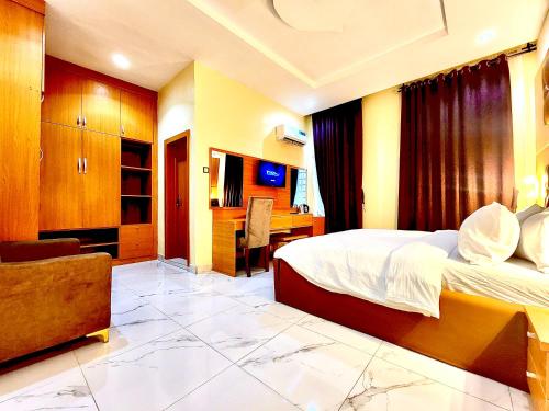 ein Hotelzimmer mit Bett und Schreibtisch in der Unterkunft Buddiez Hotel & Resort in Enugu