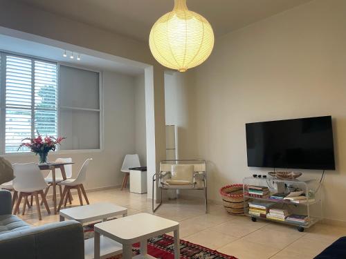ein Wohnzimmer mit einem Sofa und einem Flachbild-TV in der Unterkunft charming tlv two bedroom in Tel Aviv