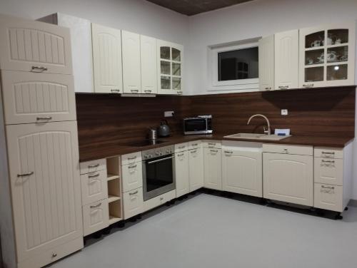 a white kitchen with white cabinets and a sink at Apartmány Svatá in Zdice