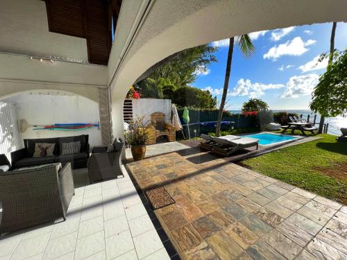 a patio with a couch and a swimming pool at Caro's Beachfront in Trou aux Biches