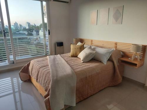 1 dormitorio con cama grande y ventana grande en Apartamento Hygge 42 en La Plata