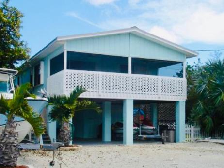 ein blaues Haus mit einem Balkon am Strand in der Unterkunft Kokomo- Canal front 2b/1bath home in Big Pine Key