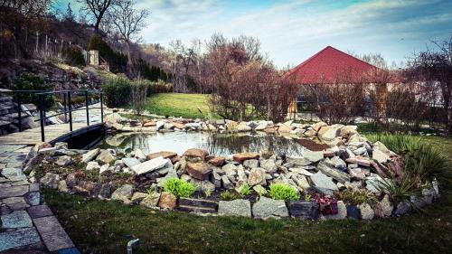 a pond with rocks in a garden with a red roof at Rezydencja Królewska in Sandomierz