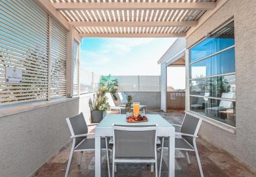 eine Terrasse mit Tisch und Stühlen auf einem Balkon in der Unterkunft סוויטות Peak - סוויטות מדהימות עם בריכה במתחם in Sifsufa