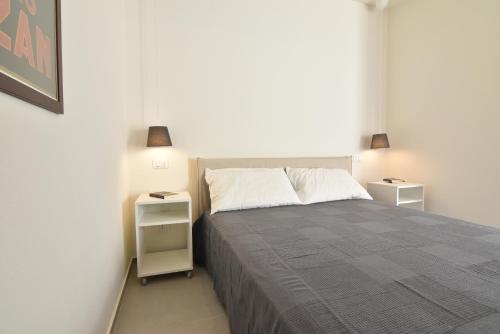 マリーナ・ディ・ラグーザにあるIn the heart of Marina di Ragusaのベッドルーム1室(大型ベッド1台、ナイトスタンド2台付)