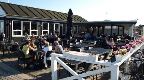 a group of people sitting at tables at a restaurant at Øster Hurup in Hadsund