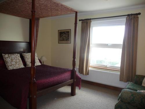 Schlafzimmer mit Himmelbett und Fenster in der Unterkunft Ivy Hall in Wootton Bridge