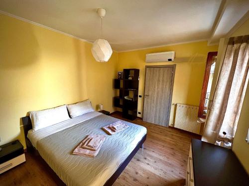 um quarto com uma cama grande num quarto com paredes amarelas em La Verbanella em Verbania