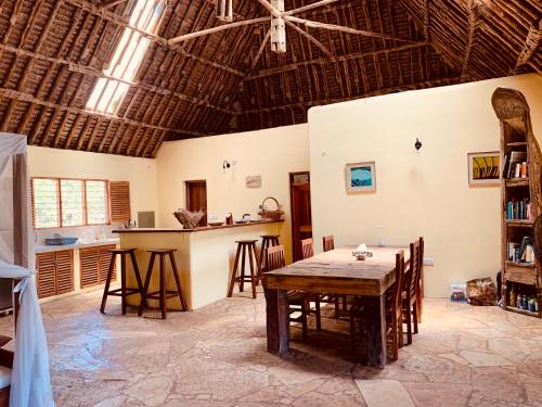 a kitchen and dining room with a table and chairs at Ushongo Beach Cottages - Family House in Tanga