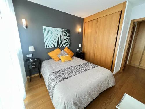 1 dormitorio con 1 cama y una foto de cebra en la pared en Elcano Bermeo By Urdaibai Rentals, en Bermeo