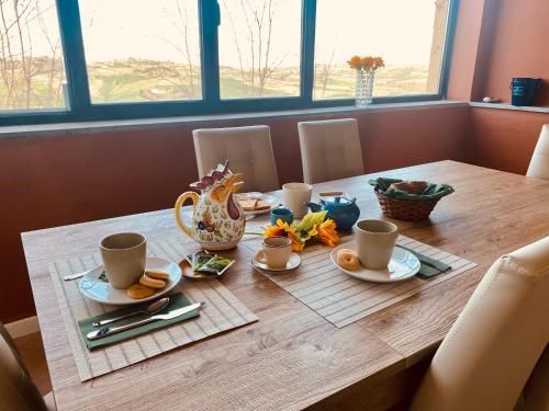 a wooden table with cups and plates of food on it at Villetta verde Smeraldo in Vignale Monferrato