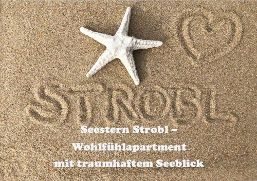 une étoile de mer sur le sable avec les mots sasakieen seizième dans l'établissement Seestern Strobl, à Strobl