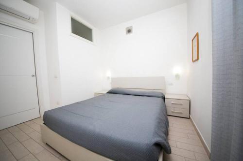 a bedroom with a bed in a white room at Miramare_5 appartamento in Castelsardo