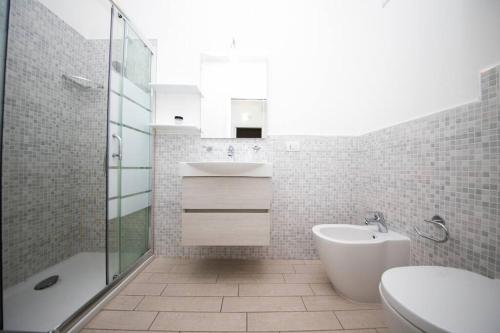 a bathroom with a sink and a toilet and a shower at Miramare_5 appartamento in Castelsardo