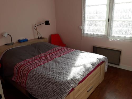 1 dormitorio con cama y ventana en Logis Letellier, en Salies-de-Béarn