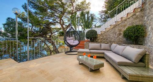 a patio with a couch and a table and stairs at Villa Eris Amalfi Coast in Conca dei Marini