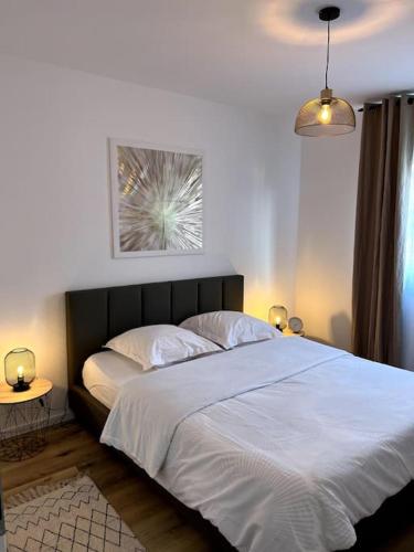מיטה או מיטות בחדר ב-Bel appartement neuf garage, parking et terrasse
