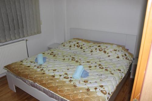 a bed with two blue candles on top of it at Apartman Romana in Doboj