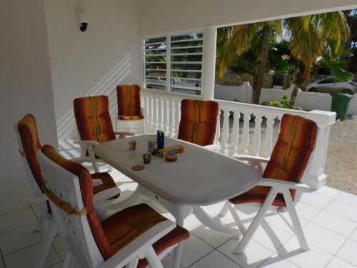 Biały stół i krzesła na ganku w obiekcie Kaya Venus Bonaire w mieście Kralendijk