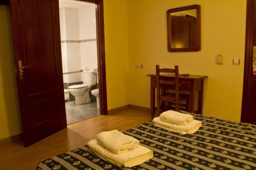 a room with a bed and a bathroom with a toilet at Hotel Clemente in Barbastro