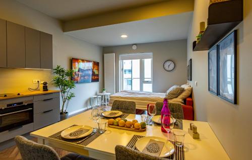 a kitchen and living room with a table and a bed at Iceland SJF Apartments - 401 in Reykjavík