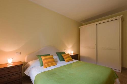 sypialnia z łóżkiem z zielonymi i żółtymi poduszkami w obiekcie Le Perle Di Golfo Aranci w mieście Golfo Aranci
