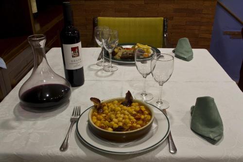 a table with a plate of food and a bottle of wine at Hotel Clemente in Barbastro