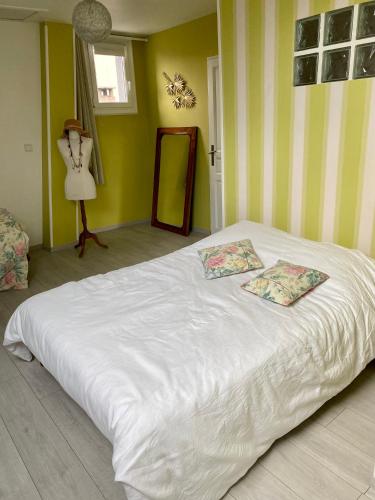 une chambre avec un lit blanc avec deux oreillers dessus dans l'établissement Chambre chez particulier, au Mans