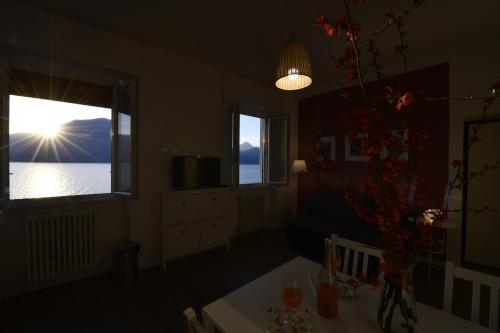 a room with a table and a window with a view of the water at Margherita House in Varenna