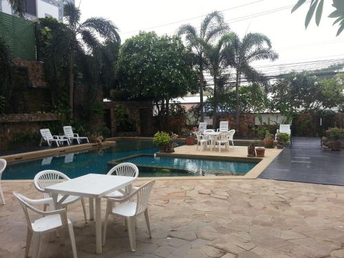 d'une terrasse avec une table et des chaises à côté de la piscine. dans l'établissement Daisy Residence, à Jomtien Beach