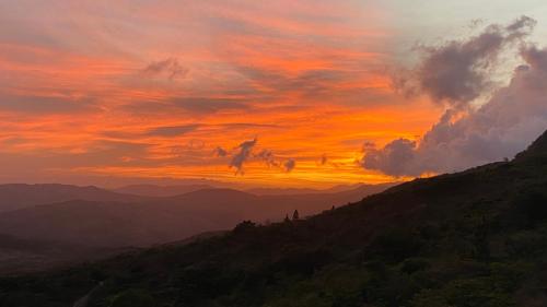 una puesta de sol sobre una cordillera con un cielo en La Qhia Eco Retreat en Santa Fe