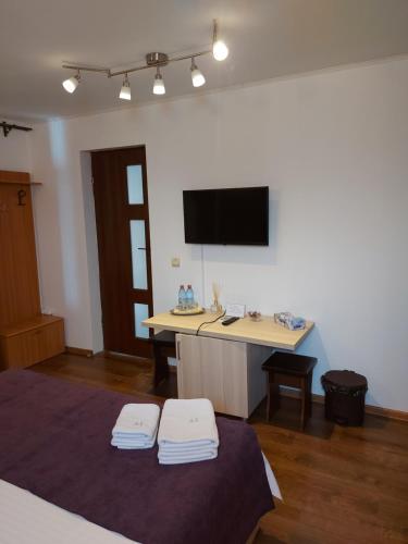 een kamer met een bureau en een tv aan de muur bij CASA IV in Vama Veche