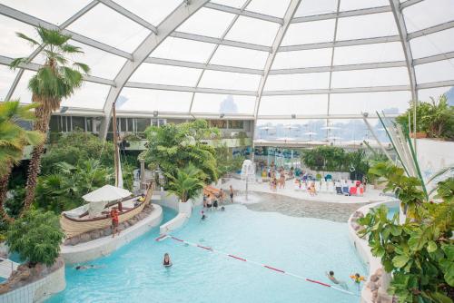 an indoor swimming pool in a building with a glass ceiling at Sunparks Oostduinkerke - Plopsaland in Oostduinkerke