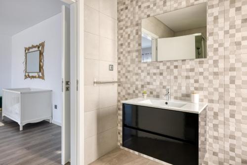 un baño con lavabo y espejo en Ocean's 8, en Lourinhã