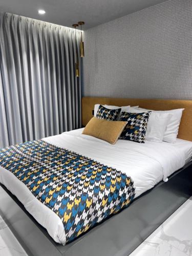 a bedroom with a large bed with colorful pillows at Saladin Boutique Hotel in Jerusalem