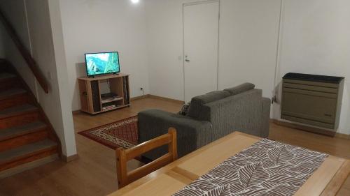 sala de estar con sofá y TV en Chocolate en Ushuaia